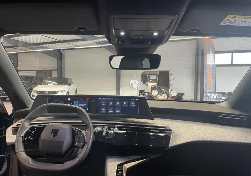 Vue intérieure avant du Peugeot 5008 2025 Bleu Obsession, tableau de bord avec double écran HD et volant compact cuir.