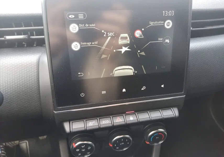 Écran tactile central de la Renault Clio V 2023 montrant l'assistance à la conduite avec commandes climatisation en dessous.