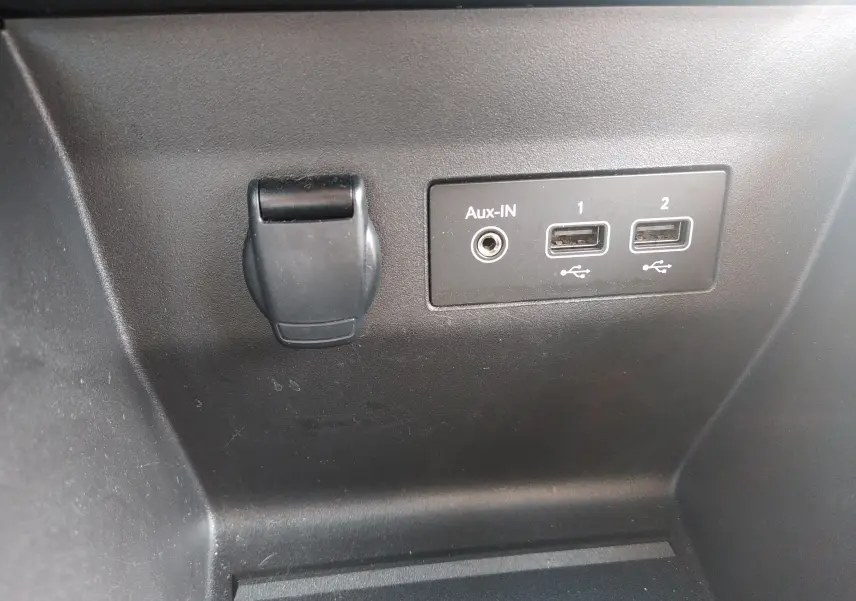 Gros plan sur les ports USB et prise Aux-IN noirs dans l’habitacle de la Renault Clio V gris 2023.