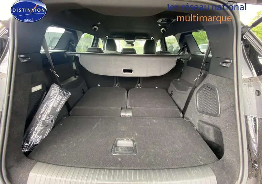 Coffre ouvert du Peugeot 5008 noir vu de l'arrière, sièges arrière rabattus offrant un grand espace de chargement.