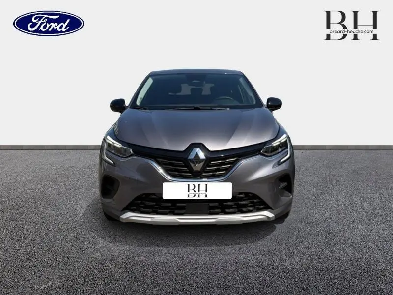 Vue avant d'un Renault Captur 1.6 E-Tech hybride gris Cassiopée métallisé avec calandre noire et phares LED.