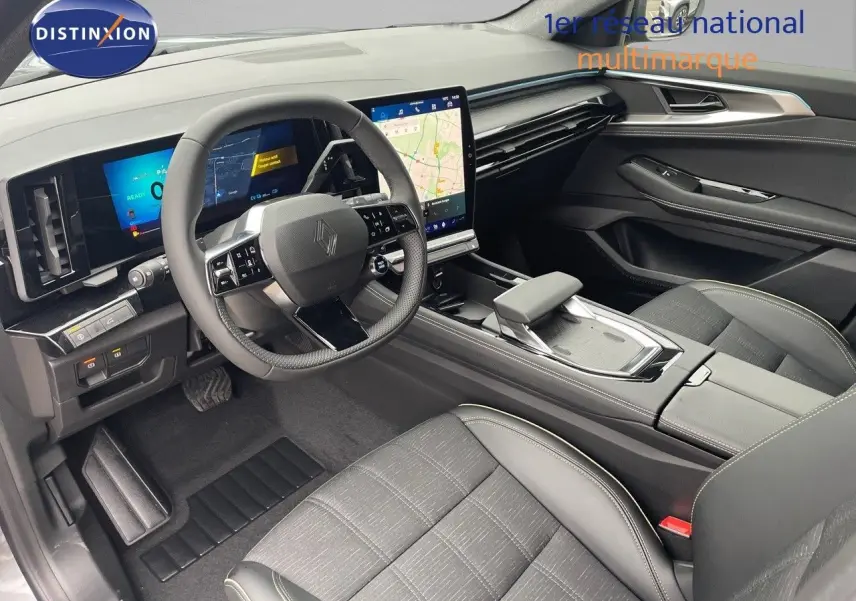 Vue intérieure côté conducteur du Renault Austral gris métal 2025, mettant en valeur le tableau de bord numérique et l’écran tactile central.