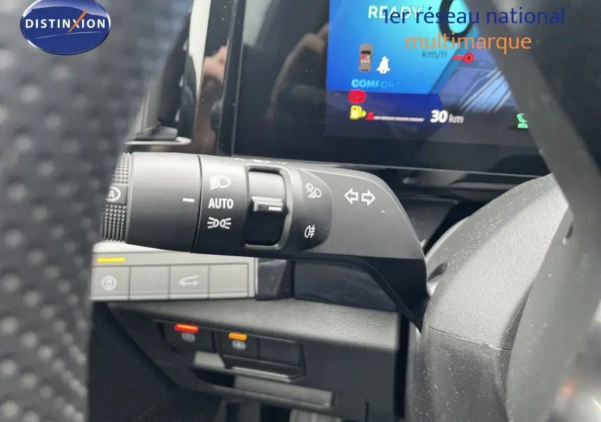 Gros plan sur la commande des feux et clignotants à gauche du volant dans l’habitacle du Renault Austral gris métal 2025.