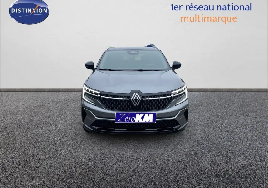 Vue frontale d’un Renault Austral gris métal 2025 avec calandre noire et feux LED allumés sur fond neutre.