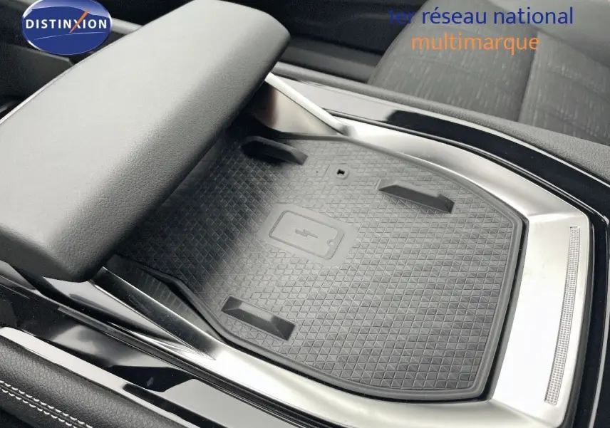 Gros plan sur le chargeur sans fil au centre console du Renault Austral gris métal 2025, finition Iconic.