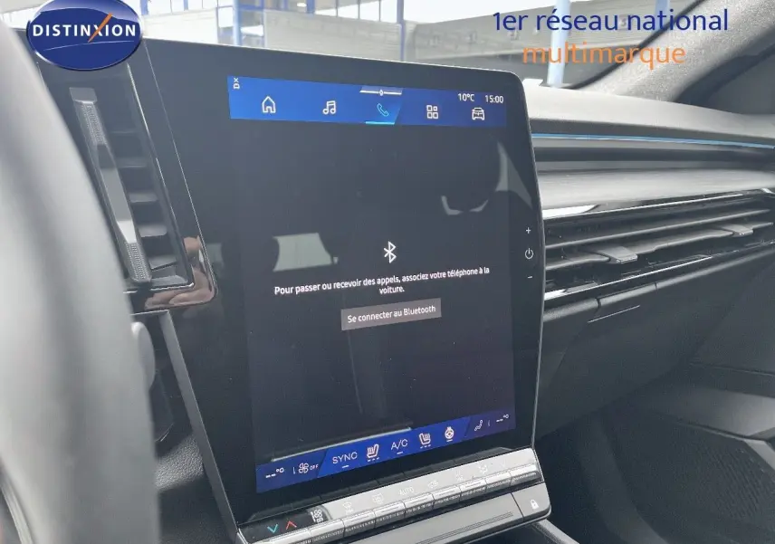 Vue intérieure centrée sur l’écran tactile du tableau de bord du Renault Austral gris métal 2025, avec commandes climatisation visibles.