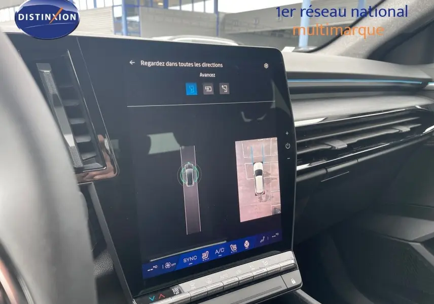 Vue intérieure du tableau de bord du Renault Austral 2025 gris métal, avec écran tactile affichant la caméra de recul et l’aide au stationnement.