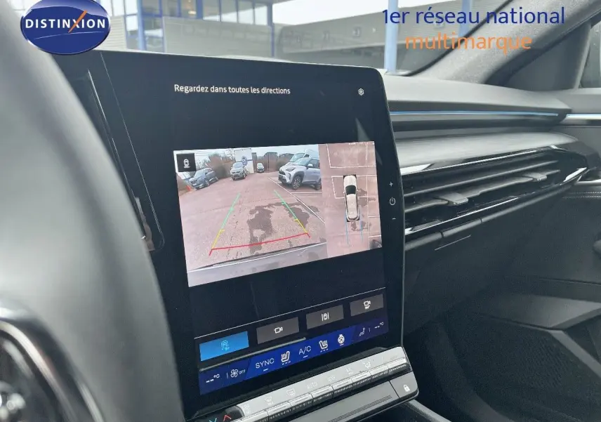 Vue intérieure du tableau de bord du Renault Austral 2025, écran tactile affichant la caméra de recul et l'aide au stationnement.
