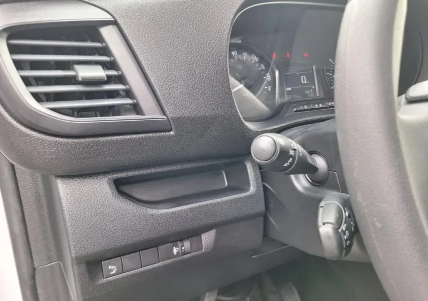 Vue intérieure côté conducteur de l'Opel Vivaro blanc 2025, montrant le tableau de bord et les commandes au volant.