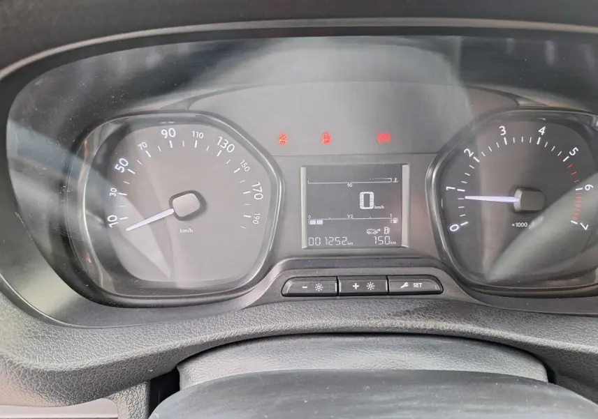 Vue rapprochée du tableau de bord noir de l'Opel Vivaro blanc, affichant compteur et écran digital.
