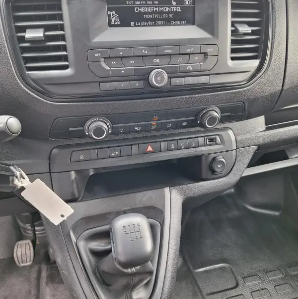 Vue intérieure centrée sur la console et levier de vitesse manuel d’un Opel Vivaro blanc de 2025.