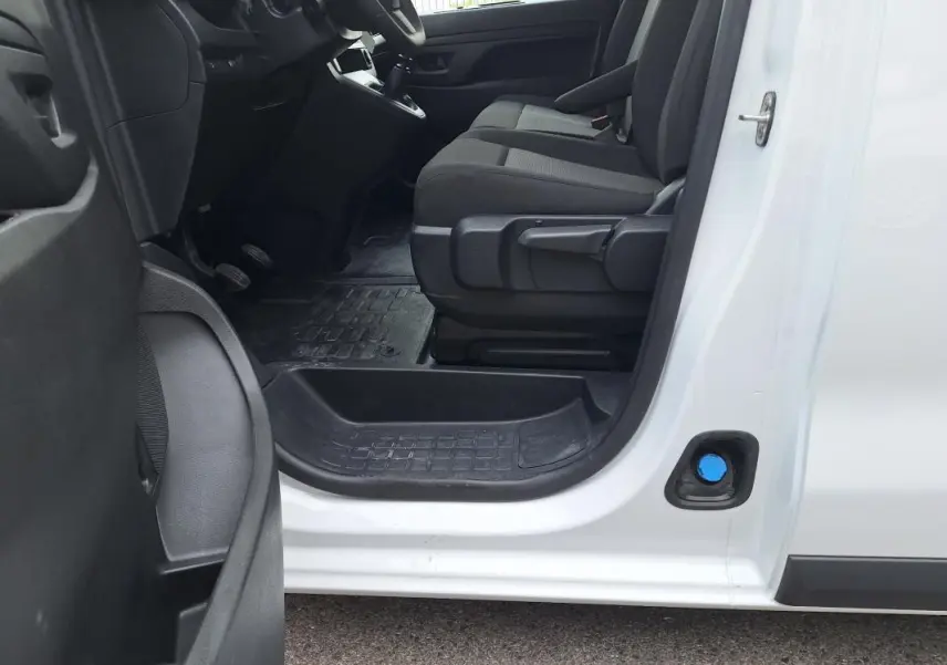 Vue intérieure côté conducteur de l’Opel Vivaro blanc 2025, montrant les sièges et le plancher en caoutchouc.
