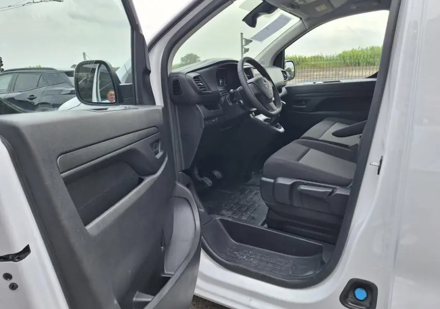 Vue intérieure côté conducteur de l’Opel Vivaro blanc 2025, montrant le tableau de bord et les sièges avant.