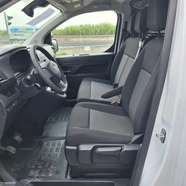 Intérieur côté conducteur de l’Opel Vivaro blanc 2025, vue sur sièges avant, volant réglable et tableau de bord.