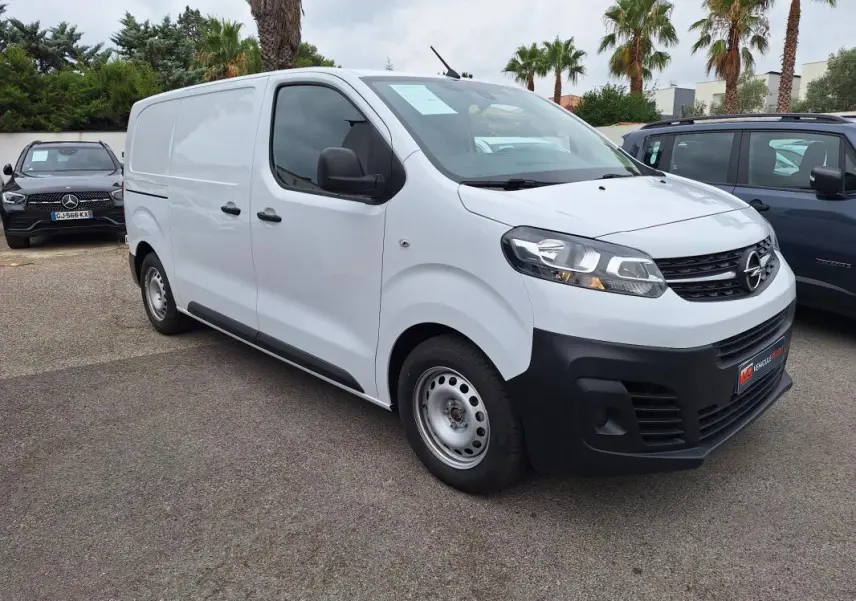 Fourgon Opel Vivaro blanc vu en 3/4 avant droit, avec porte latérale et pare-chocs noirs contrastants.