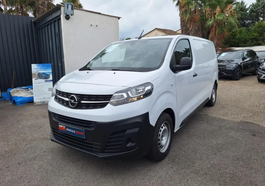 Fourgon Opel Vivaro blanc vu en 3/4 avant droit, avec pare-chocs noir et porte latérale visible.