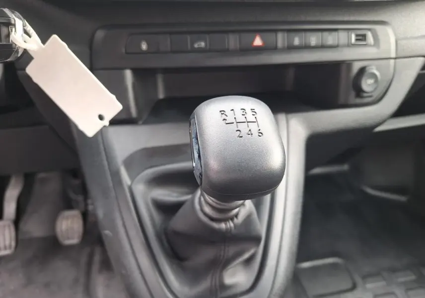 Gros plan sur le levier de vitesses manuel noir de l’Opel Vivaro 2025, intérieur gris sombre.