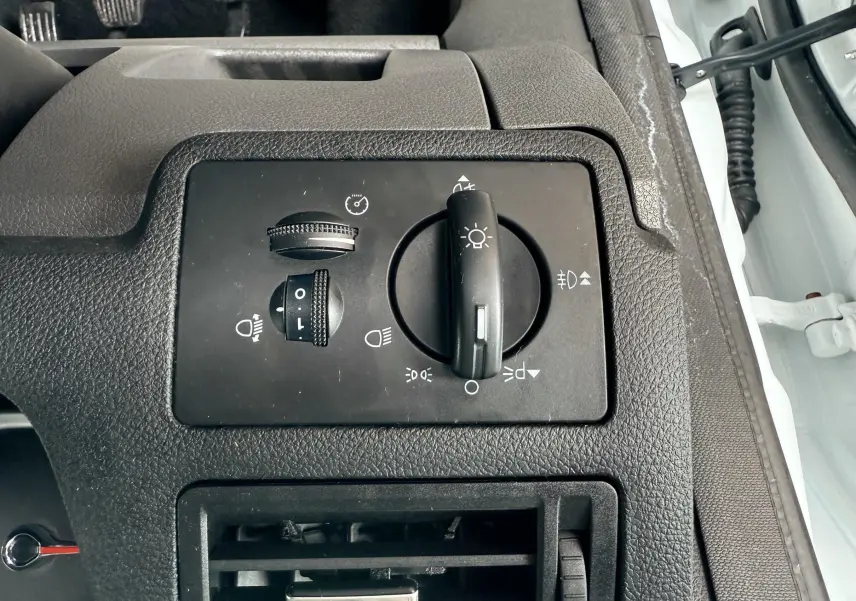 Gros plan sur les commandes d'éclairage et ventilation côté gauche intérieur d'un Ford Kuga blanc de 2012.