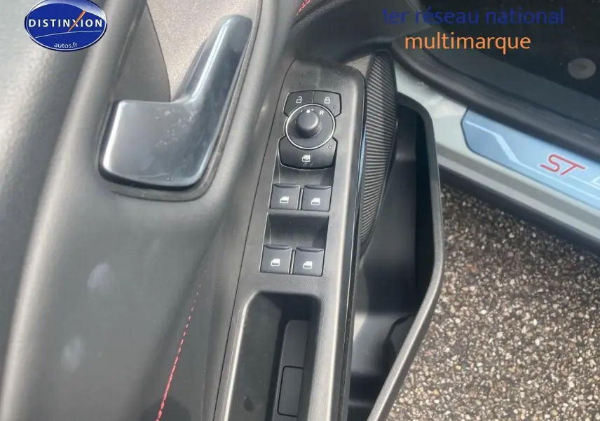 Gros plan sur la commande des vitres côté gauche d'un Ford Puma gris cactus avec seuil de porte ST visible.