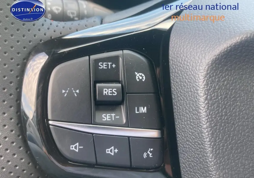 Gros plan sur les commandes au volant du Ford Puma gris cactus 2025, avec régulateur de vitesse et contrôle vocal.