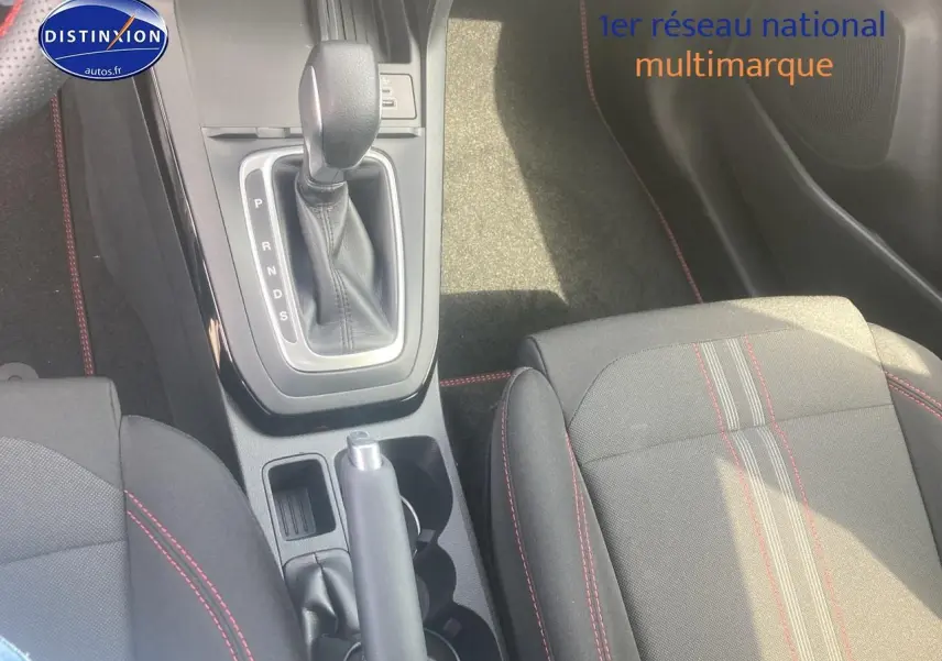 Vue plongeante sur la console centrale et les sièges tissu gris avec surpiqûres rouges du Ford Puma 2025.