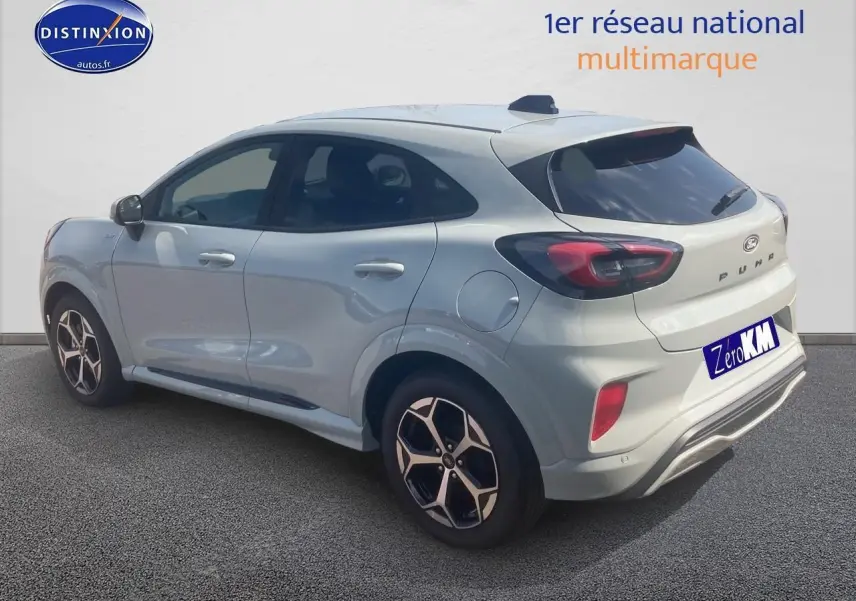Ford Puma gris cactus vu en 3/4 arrière droit, avec jantes 17 pouces et feux arrière LED distinctifs.