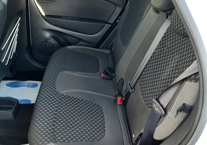 Vue intérieure côté droit montrant la banquette arrière gris noir du Renault Captur 2019 blanc nacré avec tissu à motifs.
