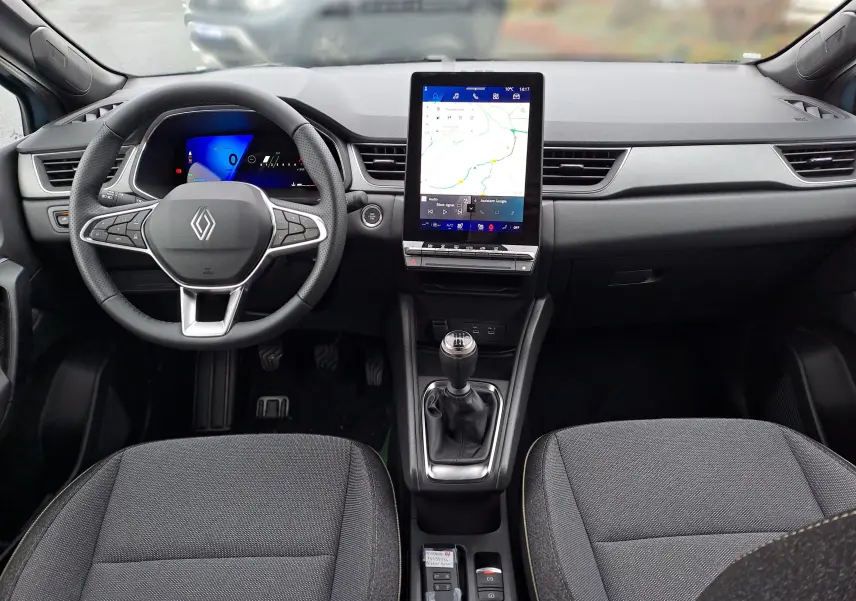 Vue intérieure avant du tableau de bord noir du Renault Symbioz avec volant multifonction et écran tactile vertical.