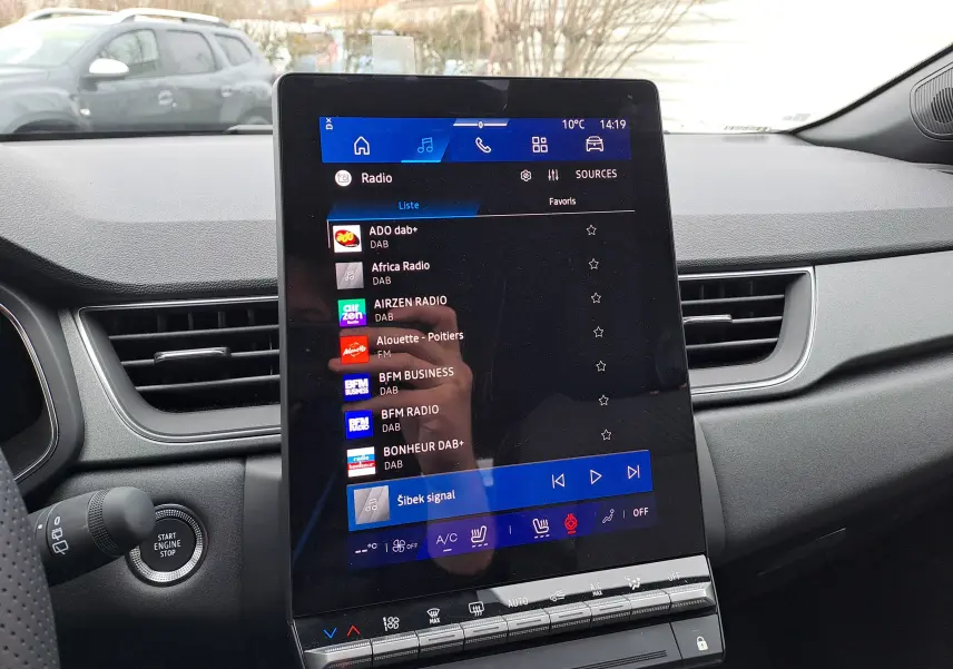 Vue rapprochée de l’écran tactile central du tableau de bord noir du Renault Symbioz 2025, affichant les stations radio DAB.