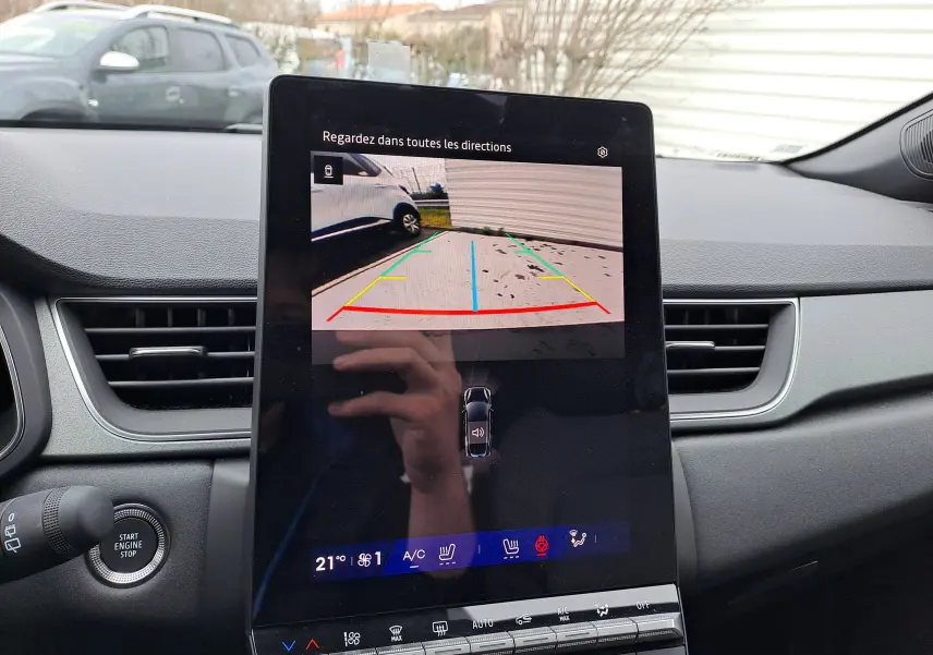 Vue intérieure centrée sur l'écran tactile du tableau de bord affichant la caméra de recul du Renault Symbioz bleu Mercure.