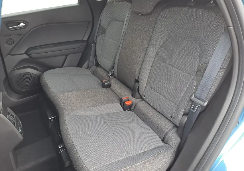 Vue latérale des sièges arrière gris foncé du Renault Symbioz 2025, avec ceinture de sécurité et porte bleu mercure partiellement visible.