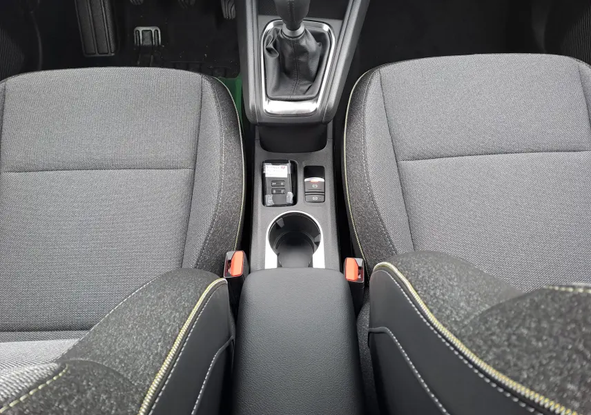 Vue plongeante sur la console centrale et les sièges avant gris foncé avec surpiqûres jaunes du Renault Symbioz MILD HYBRID.