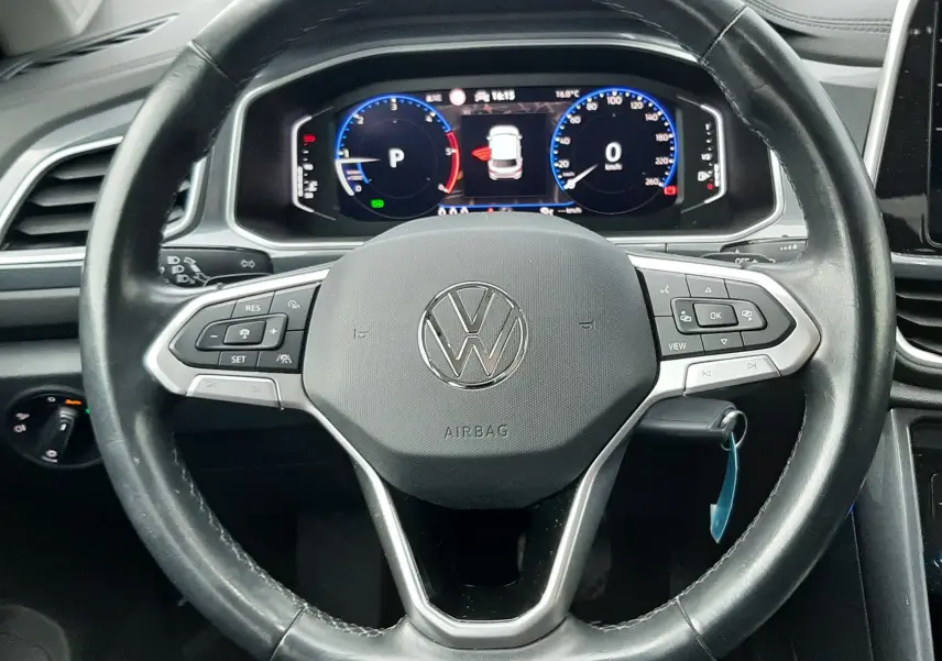Volant en cuir noir avec commandes multifonctions et tableau de bord numérique du Volkswagen T-Roc gris Pyrite 2023.