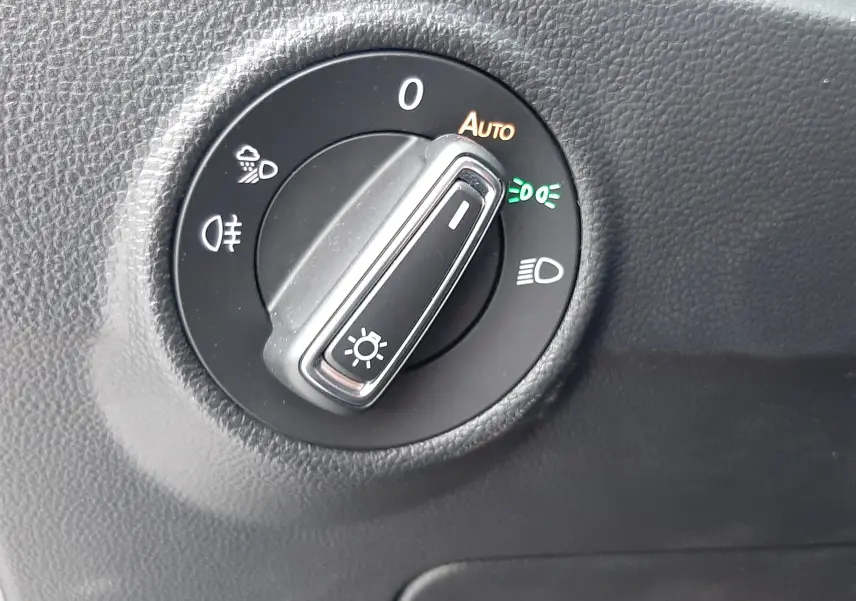 Sélecteur rotatif des phares en mode automatique sur tableau de bord noir d'un Volkswagen T-Roc 2023 gris pyrite