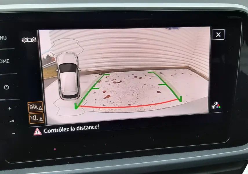 Affichage caméra de recul avec guidage vert et rouge dans un Volkswagen T-Roc gris Pyrite, vue intérieure du tableau de bord.
