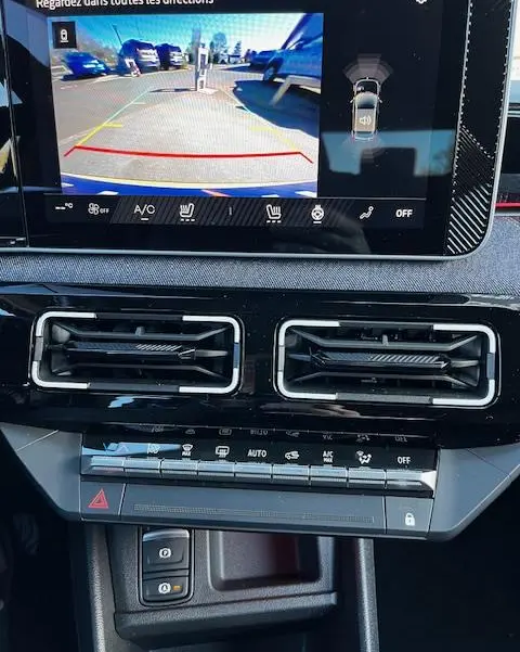 Vue rapprochée de l’écran central tactile affichant la caméra 360 d’aide au stationnement d’une Renault R5 jaune 2024.