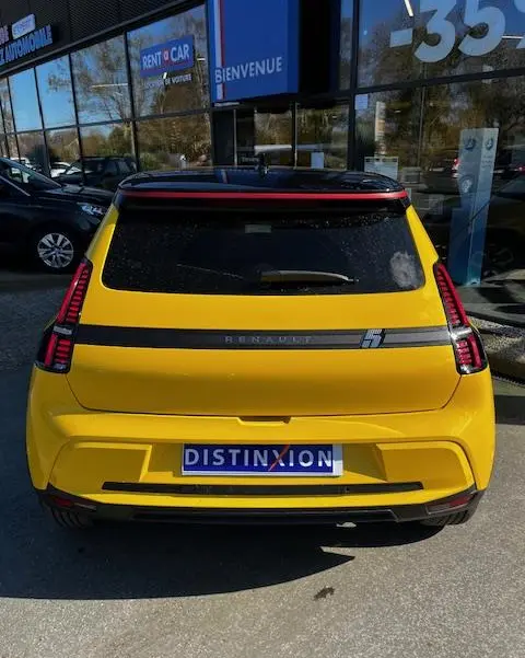 Vue arrière d'une Renault R5 Techno jaune 2024 avec feux LED verticaux et bande noire distinctive.