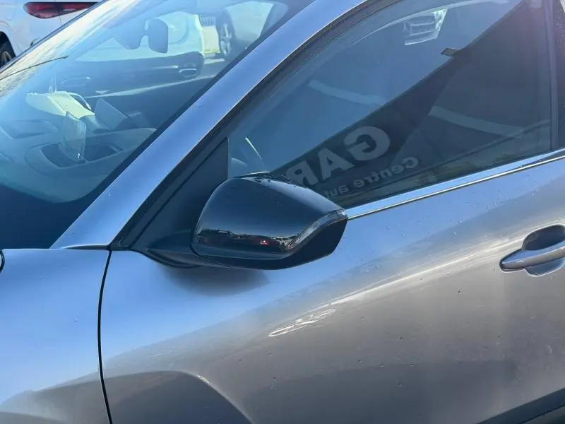 Vue rapprochée du rétroviseur côté gauche d’une Citroën C4 2024 gris acier avec poignée de porte visible.