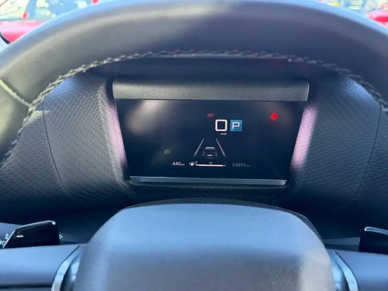 Vue intérieure centrée sur l'affichage numérique du tableau de bord du Citroën C4 2024, volant en premier plan.