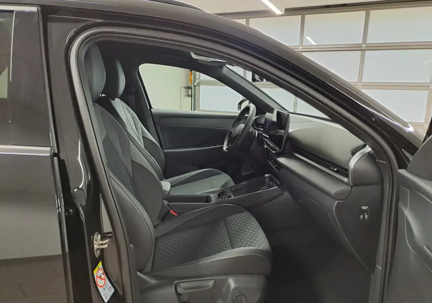 Vue intérieure côté conducteur du Volkswagen T-Roc Noir Ébène 2026, sièges noirs et tableau de bord moderne.