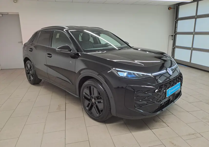 Volkswagen T-Roc 2026 noir ébène en 3/4 avant droit avec jantes noires 19 pouces et phares matrix LED allumés.