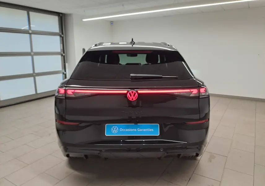 Vue arrière du Volkswagen T-Roc 2026 noir ébène avec feux LED continus et logo VW illuminé en rouge.