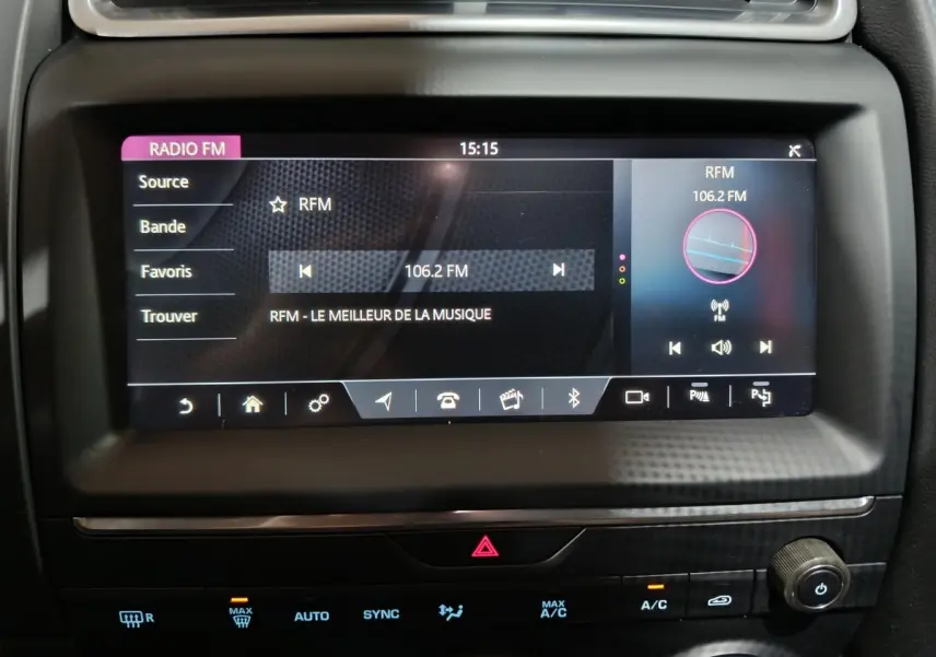 Écran tactile central allumé affichant la radio FM dans l’habitacle noir du Jaguar E-PACE P200 AWD 2019.