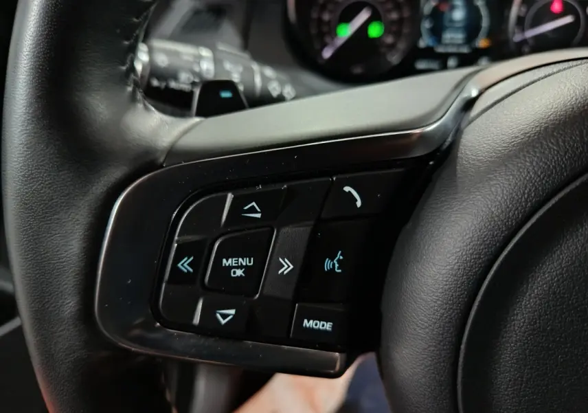 Gros plan sur les commandes multifonctions en cuir du volant gauche du Jaguar E-PACE noir, version 2019.