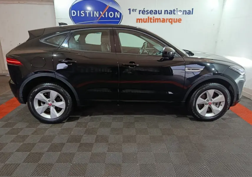 Vue de profil côté gauche d'un Jaguar E-PACE noir 2019 garé en intérieur avec jantes argentées et logo Jaguar visible.
