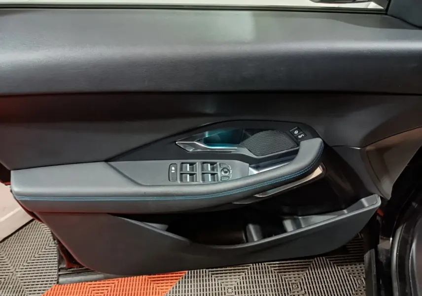 Vue rapprochée de la porte avant gauche noire du Jaguar E-PACE 2019, avec commandes électriques et finition cuir.