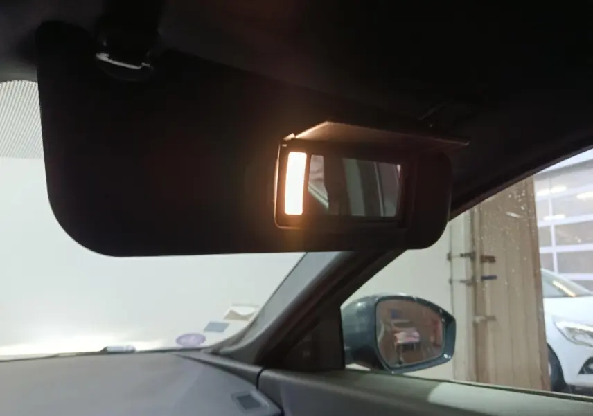 Détail intérieur du pare-soleil côté conducteur avec miroir éclairé sur Jaguar E-PACE noir, vue côté gauche.
