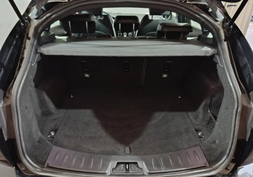 Vue arrière du coffre noir de la Jaguar E-PACE 2019, version R-DYNAMIC S, avec tablette cache-bagages déployée.