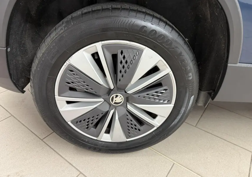 Gros plan sur la roue avant droite du Skoda Karoq bleu lave, avec jante design et pneu Goodyear visible.