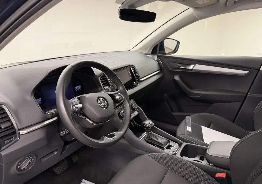 Vue intérieure côté conducteur du Skoda Karoq 2023 avec tableau de bord moderne et volant multifonction noir.